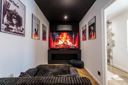 a bedroom with a fireplace and a tv on the wall at Saga - Cinema Room - By Primo in Chagny