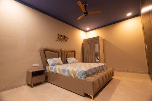 a bedroom with a bed with a ceiling fan at Annapurna Home in Noida