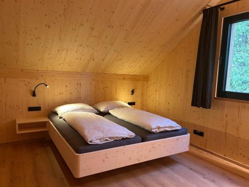 a bedroom with a bed in a wooden room at Ferienhaus Mayka in Hochrindl