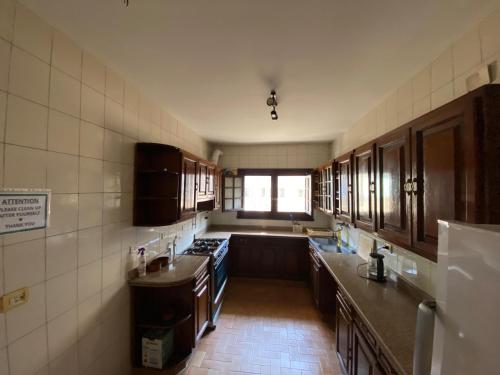 a kitchen with wooden cabinets and a sink and a window at A private room by the rooftop in Cairo
