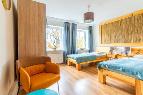 une chambre d'hôtel avec deux lits et une chaise et un lit dans l'établissement W parku przy teatrze, à Szczawno-Zdrój