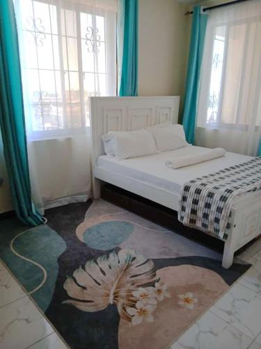 a bedroom with a white bed with blue curtains at Azuka Luxury in Mombasa