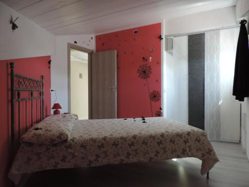 een slaapkamer met een bed en een rode muur bij Villa Boemia - apartment in Coriano