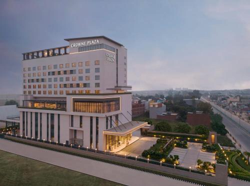 a large white building with lights in a city at Crowne Plaza Lucknow by IHG in Lucknow