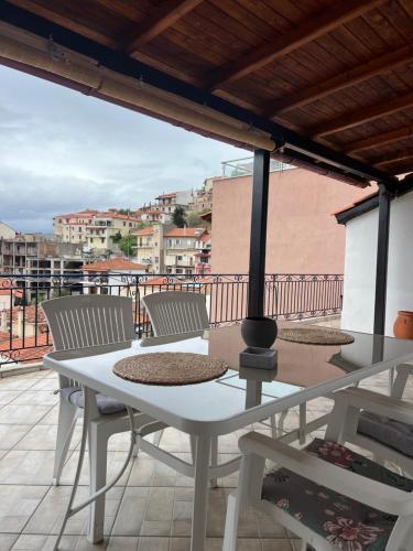 a white table and chairs on a balcony with a view at Kyparissos Home , Arachova in Arachova