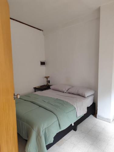 a bed in a bedroom with a white wall at Libertador 6 MVD in Montevideo