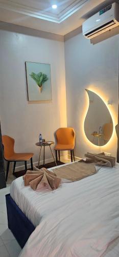 a bedroom with a bed and two chairs and a table at Roak Hotels and Apartments in Abuja