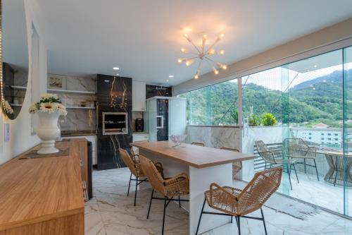 a kitchen and dining room with a table and chairs at Loft c Varanda, Piscina e Academia em Itacuruca in Itacuruçá