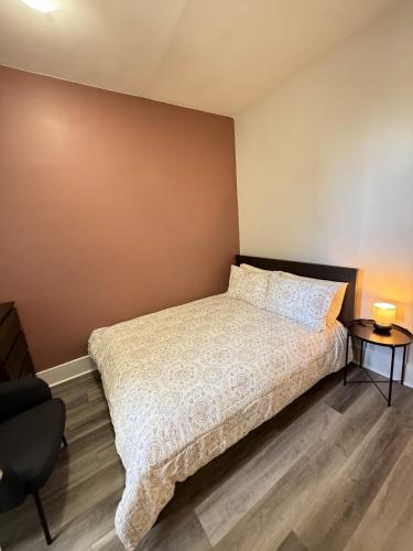 a bedroom with a bed and a chair at Second Floor Apartment in Victorian House in Strathroy