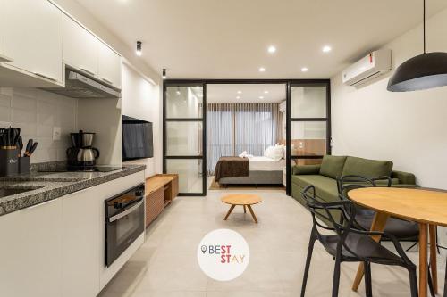 a kitchen and living room with a table and a bed at Charmosos Apartamentos Reformados na Glória in Rio de Janeiro