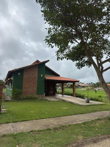 a small green building with a tree in a field at Casa Verde Jade in Areia