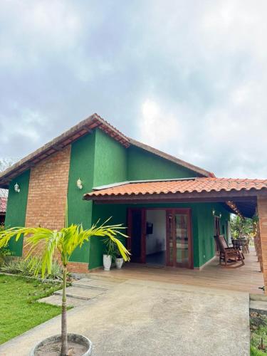 a green house with a palm tree in front of it at Casa Verde Jade in Areia