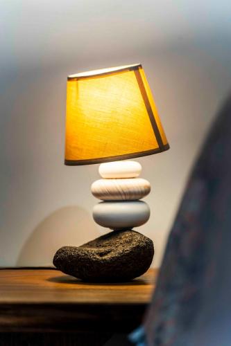 a stack of rocks sitting on a table with a lamp at Fare Mihiau Moorea in Irioa