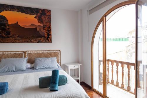 a bedroom with a bed with a large painting on the wall at Casa Salvador in Agaete