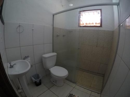 a bathroom with a shower and a toilet and a sink at Pousada Ana Maria in Delfinópolis