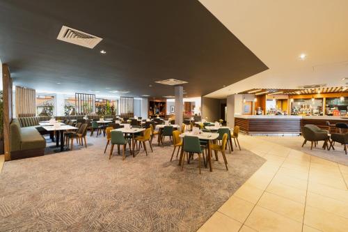 a restaurant with tables and chairs and a bar at Holiday Inn Newcastle South by IHG in Boldon