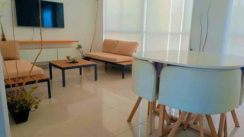 a living room with a table and a couch at Departamento con cochera - Condominio Las Flores in Ica