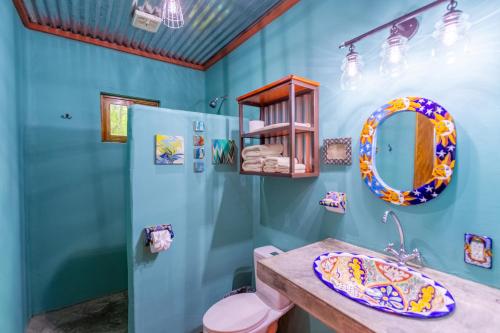 une salle de bain avec des murs bleus et des toilettes et un lavabo roses dans l'établissement Morrillo Beach Eco Resort, à Morrillo