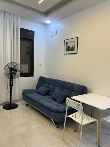 un salon avec un canapé bleu et une table dans l'établissement Nice place, à Irbid