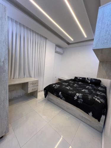 Nice place في إربد: غرفة نوم بها سرير أسود وطاولة