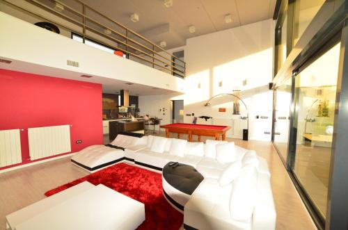 sala de estar con sofá blanco y pared roja en Futurcasa Casa rural Spa y cine, en La Felipa