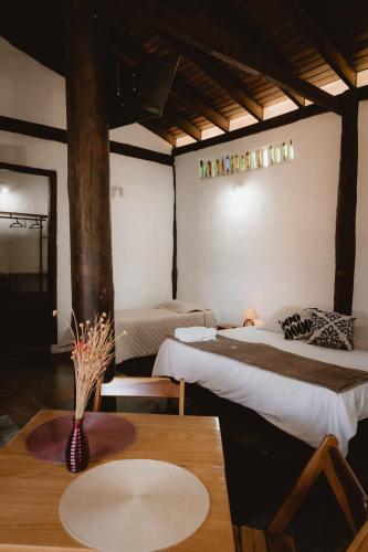 a room with two beds and a table with a plate on it at Pousada Mãe Terra in Torrinha