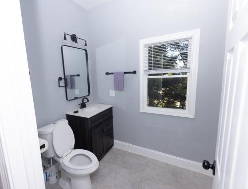 een badkamer met toilet, wastafel en raam bij The Happy Place in Brockton