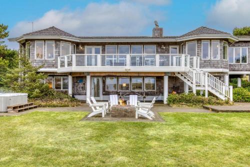 シーサイドにあるElk Ridge - Lux oceanfront family retreatのパティオと芝生のある大きな家