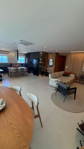 Apt luxo vista mar 160m com jacuzzi e 2 garagens في ايتابيما: غرفة معيشة بها أريكة وطاولة