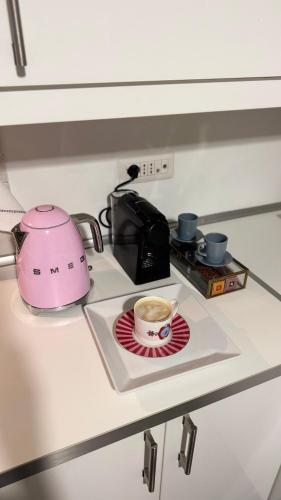 a pink toaster and a cup of coffee on a counter at Riva in Pozzuoli