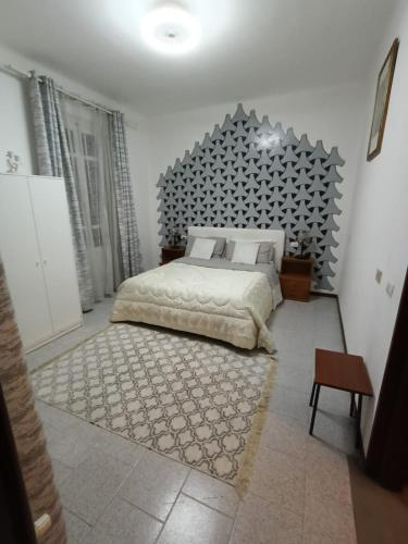 a bedroom with a large bed with a large headboard at Room e Breakfast Diana e Ninni Salsomaggiore Terme in Salsomaggiore Terme