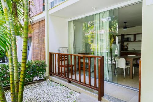 a balcony with glass doors and a table with a dining room at Para Vos y Porque Si in Morro de São Paulo