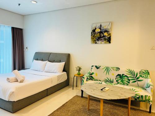 Mercu Summer Comfort Luxe Suites By KLCC في كوالالمبور: غرفة نوم بها سرير وأريكة
