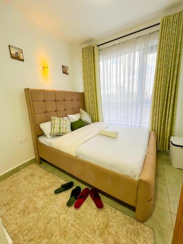 a bedroom with a bed with shoes on the floor at Ellber Homes in Nairobi