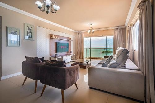 a living room with two couches and a television at IPTZ170- Frente mar c/ vista incrível do 17º andar in Balneário Camboriú