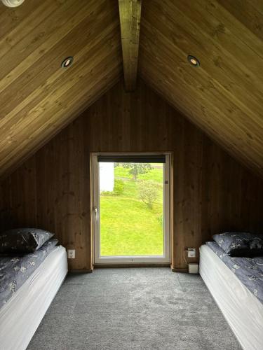 a room with two beds and a large window at Architectural gem with fjord view in Holmedal