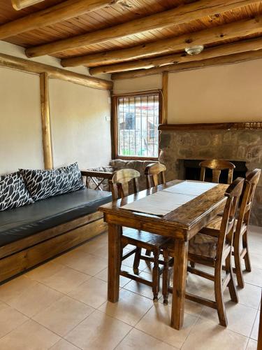 Cabañas del Pasaje في Las Compuertas: غرفة طعام مع طاولة وكراسي وأريكة