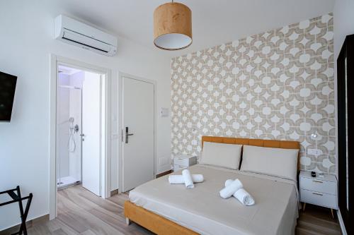 ein Schlafzimmer mit einem Bett mit zwei Handtüchern darauf in der Unterkunft Colorful Home in Mailand