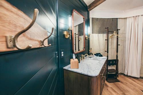 a bathroom with a sink and a mirror at Luxuring Glamping Tent - The Dog Wood - Near Tryon International Equestrian Center - Wheat Creek Outpost in Mill Spring