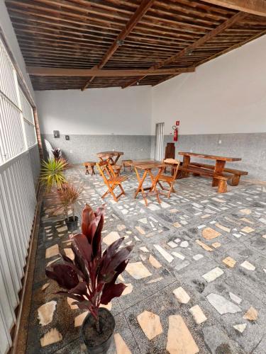 Un patio con mesas de picnic en una habitación. en La Palma Hostel, en Maragogi