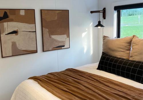 een slaapkamer met een bed met twee foto's aan de muur bij Scenic Ridge Haven Firepit, Trails & Views 