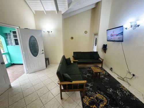 a living room with a couch and a table at Tropical Breeze Grenada in Westerhall Land Settlement