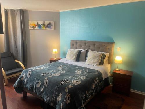 Un dormitorio con una cama y una pared azul. en Foresta Urban Suites, en Santiago