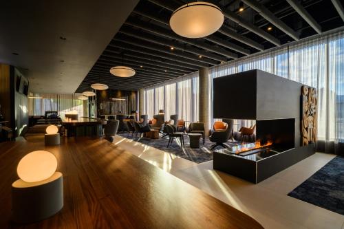 a lobby with a fireplace and chairs and tables at Hyatt Place Whitehorse in Whitehorse