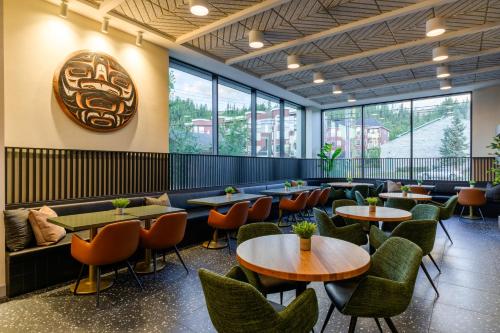 a restaurant with tables and chairs and windows at Hyatt Place Whitehorse in Whitehorse