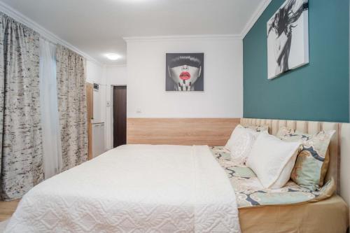 a bedroom with a large white bed and blue walls at Airport Connection in Iaşi