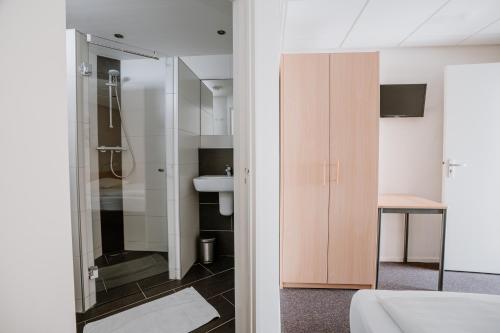 een badkamer met douche en wastafel bij Hotel Kodde in Aagtekerke