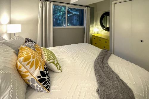 a bedroom with a bed with pillows and a window at Walk to Beach and Village Bainbridge Island Gem! in Lynwood Center