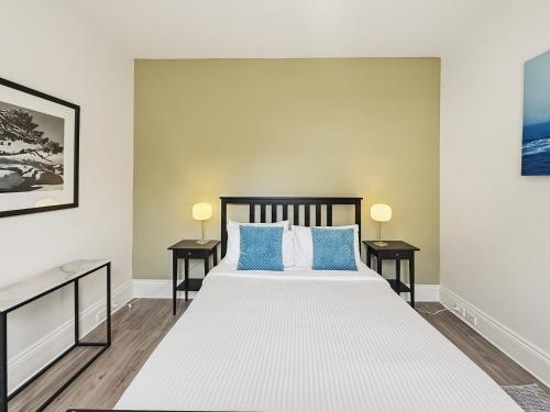 a bedroom with a large bed with blue pillows at Charming 1 bedroom, park adjacent. city 5 minutes in Sydney