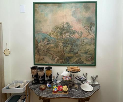 een tafel met eten erop met een schilderij aan de muur bij Le Balze Camere in Villa in Perugia